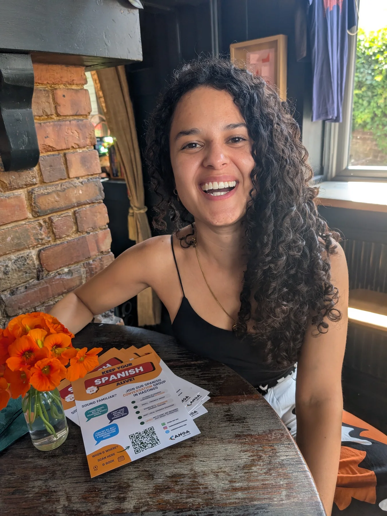 Jenifer smiling at a table during a Canoa Local session